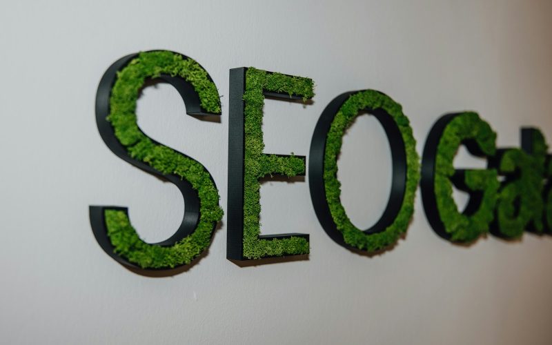 a close up of a sign with grass on it