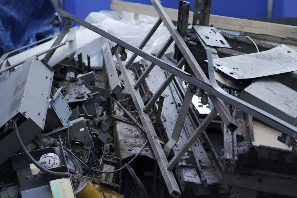 a pile of metal scrap next to a blue wall